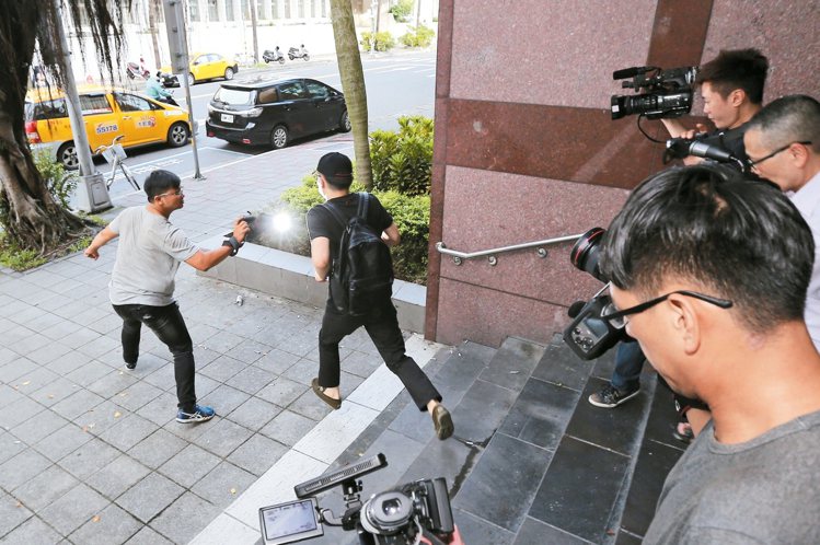 面對媒體記者詢問是否冤枉，楊瑞仁（右）只說：不是冤枉後，突然快跑上計程車。 記者...