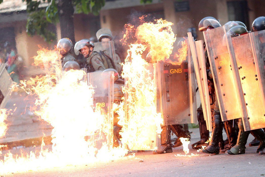 委內瑞拉鎮暴部隊去年七月在首都卡拉卡斯，與反政府示威者發生衝突，身上著火。（路透...