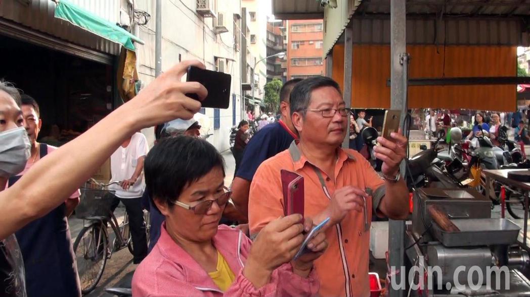   Ma Ying-jeou went to the market to sweep the streets, many people hurried to take their mobile phones to take pictures. Reporter Wang Zhaoyue / Photography 