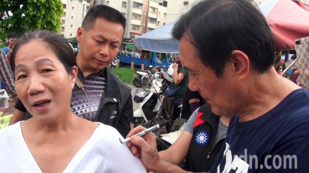  Ma Ying-jeou accompanied market participants to sweep the street, a woman who sued Ma Ying-jeou to sign. 