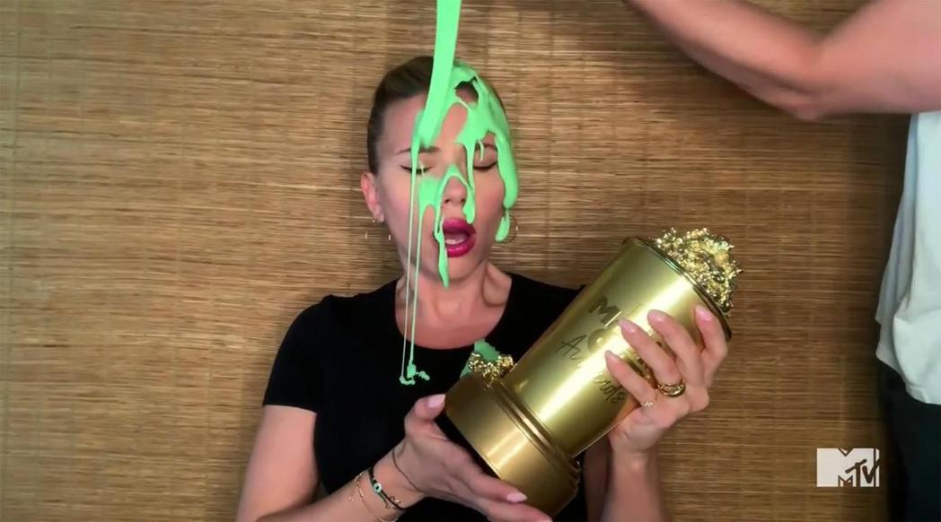 思嘉莉約翰森在家中領取MTV世代特別獎，卻被老公倒了一頭綠液。圖／摘自MTV