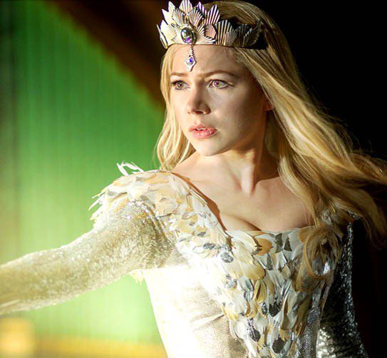 蜜雪兒威廉斯飾演頂著一頭金色波浪長髮，穿上白銀配色的服裝，頭戴皇冠詮釋著《奧茲大帝》裡擁有強大力量但卻心地善良的北國好女巫。圖／擷取自迪士尼官網
