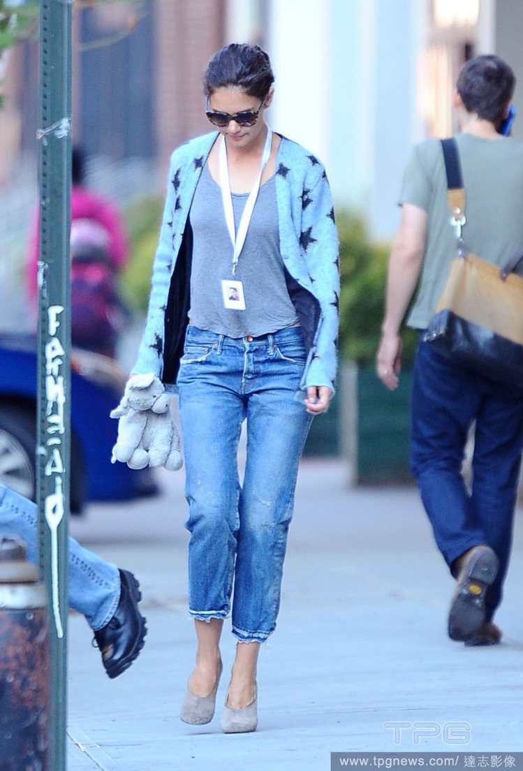 凱蒂荷姆斯的 YSL 毛衣外套有著甜美的粉藍配色，印上街頭風黑色星星圖案更加亮眼活潑。搭配寬鬆牛仔褲和灰色麂皮淺口跟鞋隨性自在，看她起來瞬間年輕許多。圖／達志影像