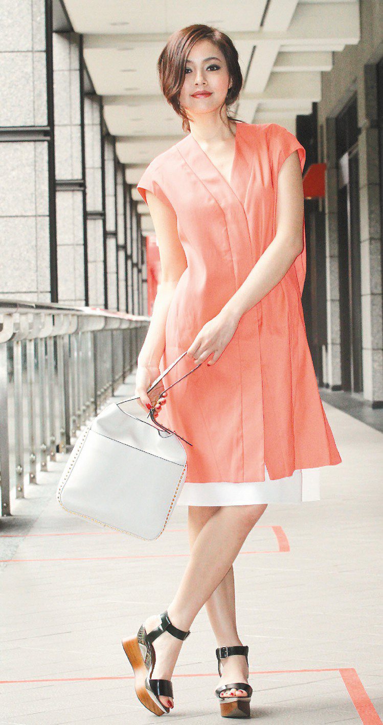 模特兒穿MARNI春夏粉橘色上衣54,900元、白裙26,900元、包款50,900元。記者黃義書／攝影