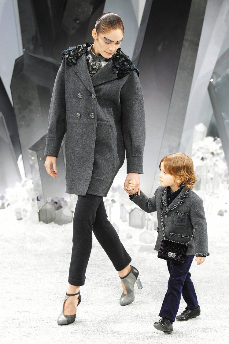 在水晶森林中，模特兒牽著3歲小男孩走香奈兒秀，搭小皮包超可愛。圖／路透