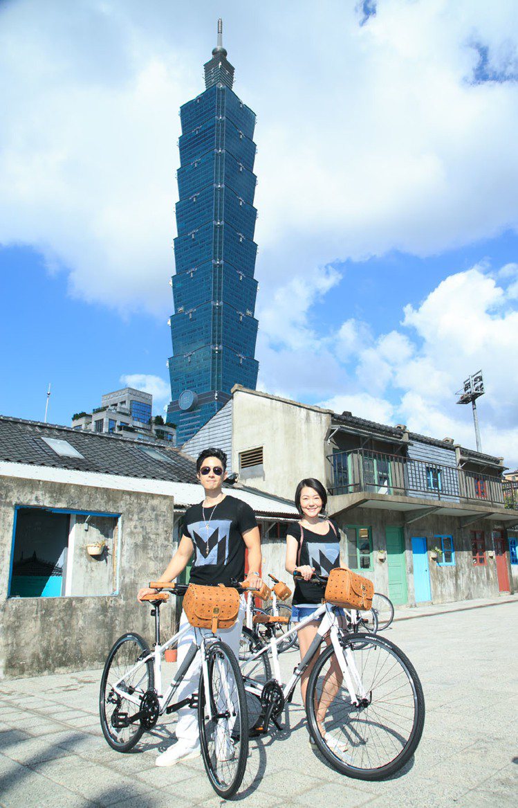 「MCM遇見台北 - M Bike活動」，小S與吳建豪騎上M Bike於四四南村前合影留念。圖／MCM提供
