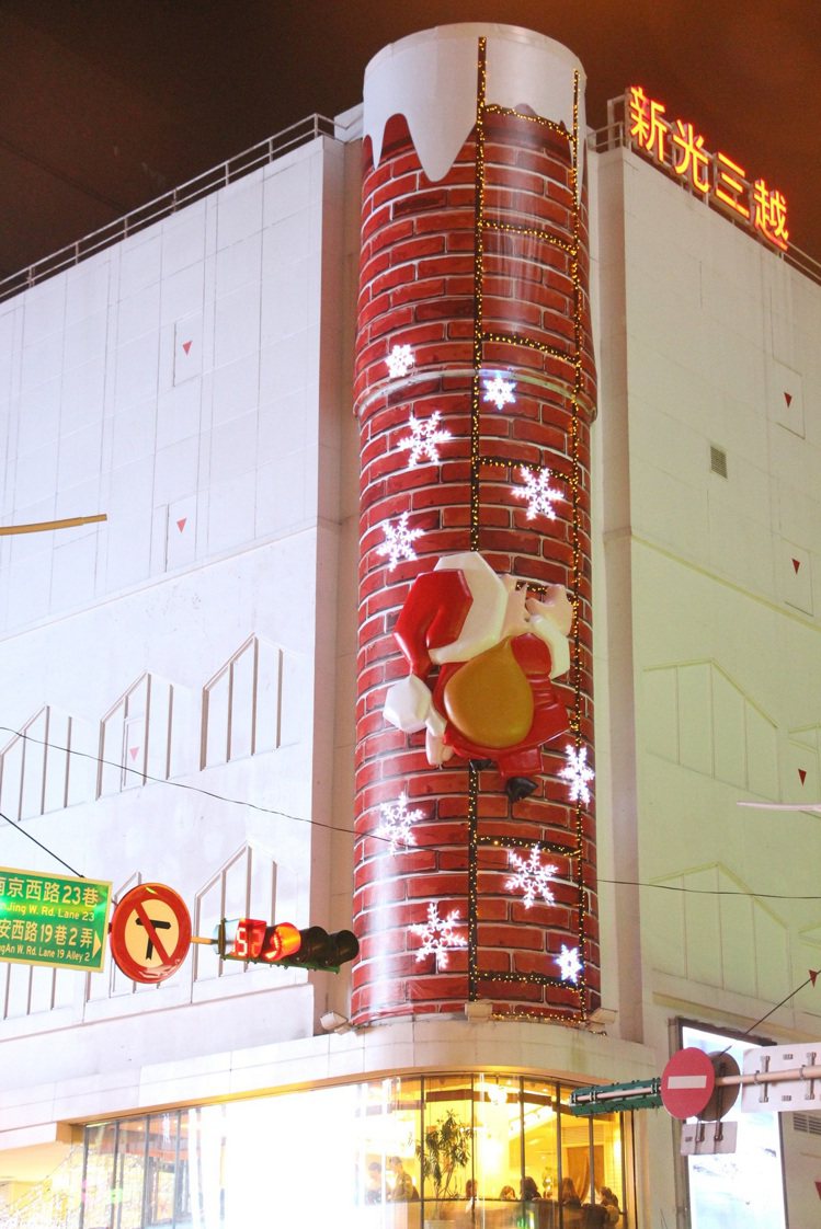 耶誕老人俏皮的爬上新光三越台北南西店二館外的圓柱外牆。圖／新光三越提供