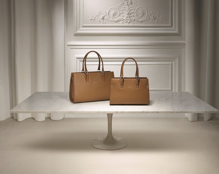 為慶祝Longchamp於1988年在聖奧雷諾路Rue Saint-Honoré上開設的旗艦店翻新，推出向經典致敬的 Paris Premier系列，台灣也將於10月中開賣。圖為2種尺寸Paris Premier褐色款手提包。圖／Longchamp提供