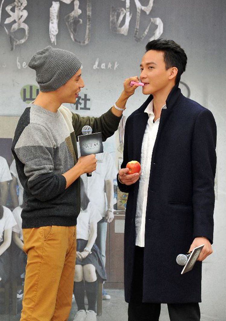 徐鈞浩（左）幫曹晏豪塗天台之吻用的草莓護唇膏。圖／台視提供