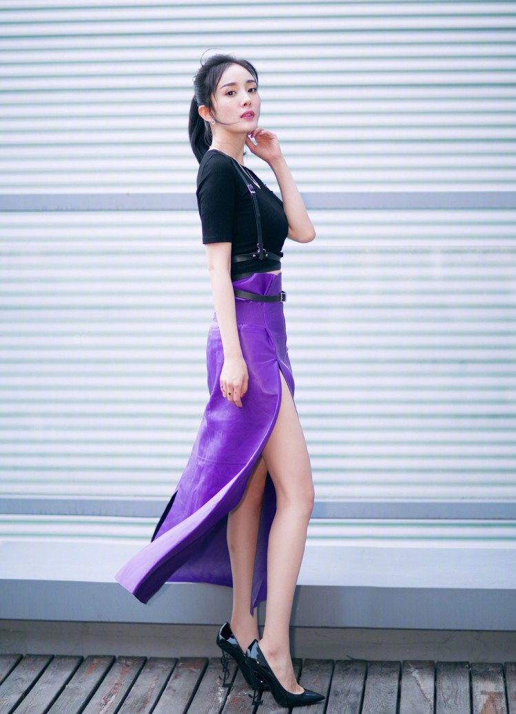 楊冪參加大陸火紅的真人秀節目「明星之子」錄影，穿黑色上衣搭配Ferragamo紫色皮裙，開高衩的設計大秀美腿，腳踩Saint Laurent高跟鞋拉長整體線條。圖／Ferragamo提供