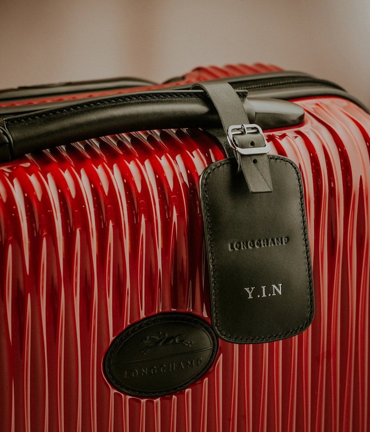 劉仁娜專屬Fairval行李箱附有壓印名字縮寫的「YIN」皮革行李吊牌。圖／Longchamp提供
