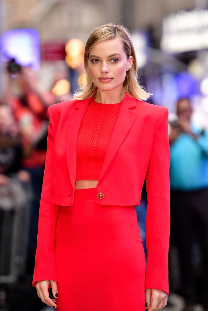 瑪格羅比穿著VERSACE 2018春夏女裝系列摩登紅色經典套裝，於美國ABC電視節目早安美國拍攝現場。圖／VERSACE提供