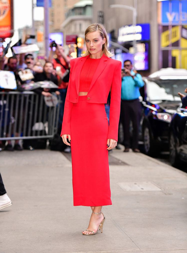 瑪格羅比穿著VERSACE 2018春夏女裝系列摩登紅色經典套裝，於美國ABC電視節目早安美國拍攝現場。圖／VERSACE提供