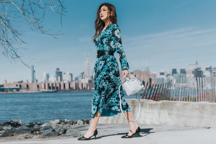 Selina穿湖藍色印花長裙9,700元、Nolita白色提包16,200元、Gia尖頭中跟鞋6,800元。圖／MICHAEL KORS提供