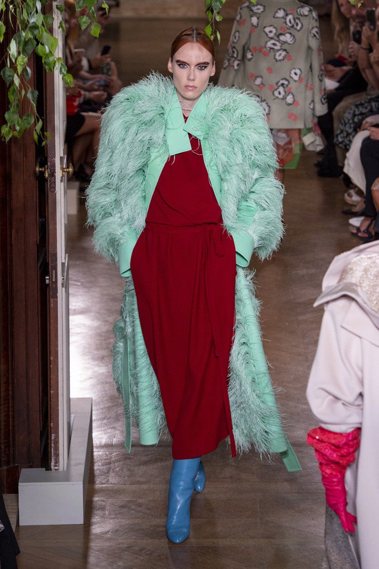 Valentino秋冬高級訂製服可見湖水綠的羽毛裝飾大衣搭配了磚紅裙裝、水藍色鞋履，創造了強列的對比感。圖／美聯社