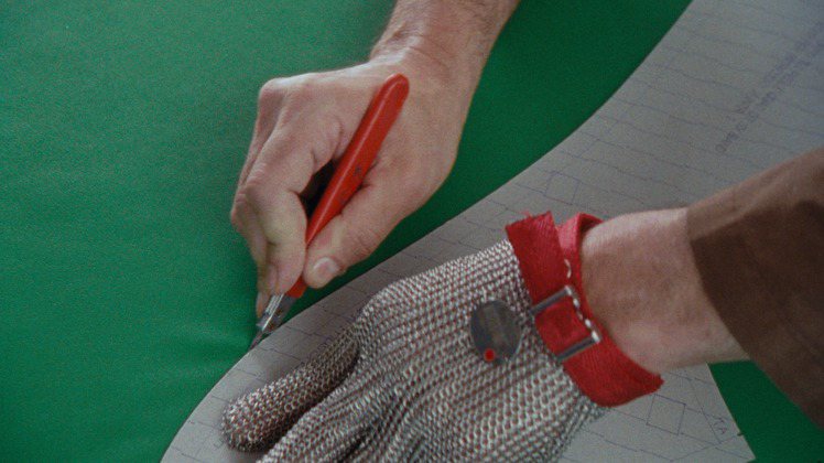 單手穿上軟甲手套、一手裁切皮革的過程，展現了軟與硬、原始與精準的比對。圖／Bottega Veneta提供