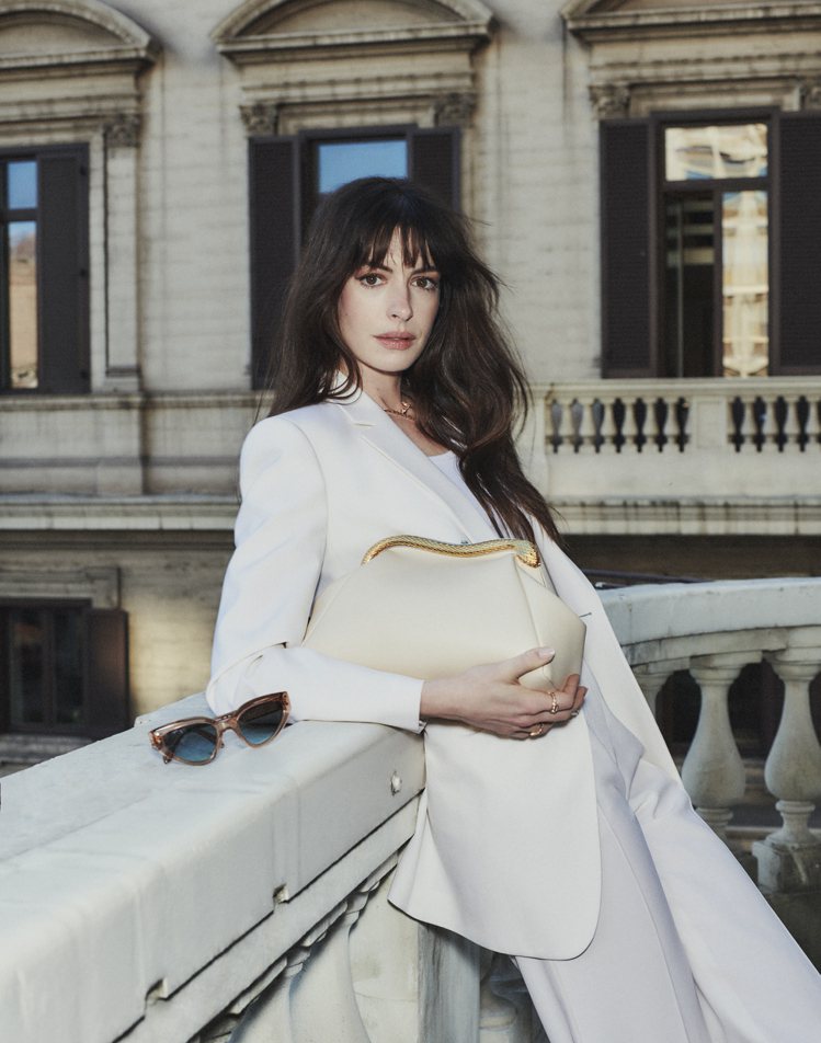 寶格麗品牌代言人安海瑟薇白色套裝搭配BVLGARI SERPENTINE POUCH象牙蛋白石色小牛皮手拿包。圖／寶格麗提供