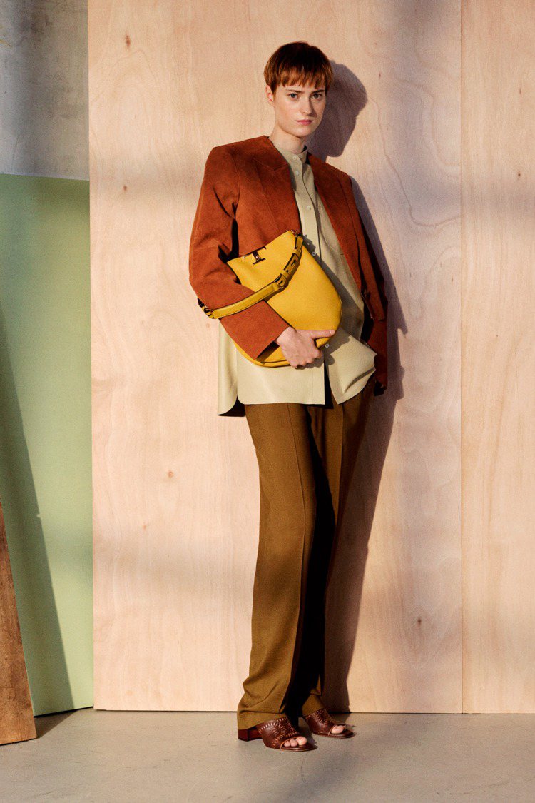 無領口的麂皮西裝外套配上長襯衫與黃色肩背包，展現出舒適的愜意風格。圖／TOD'S提供