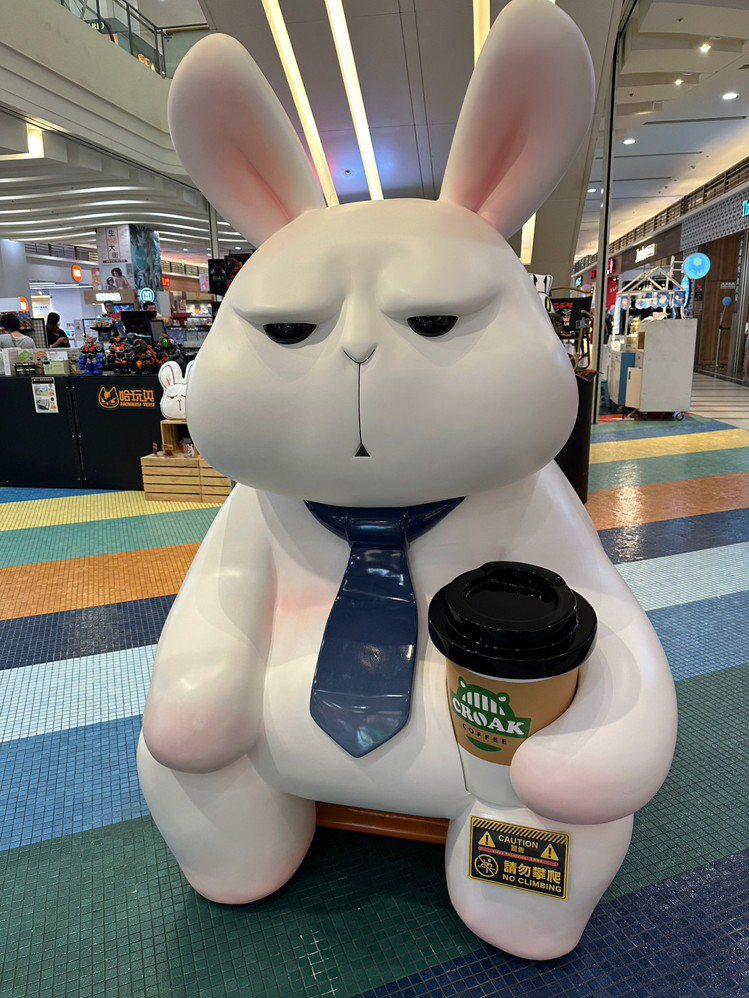 Global Mall新北中和推出大人系玩具主題專區，厭世兔兔「星期一的布魯斯」大型公仔坐在快閃店門口。圖／Global Mall提供