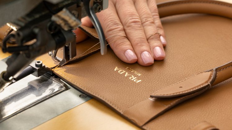 包款表面並有22K燙金的Prada Milano標誌，展現品牌身為米蘭精品大廠對工藝的自信宣示。圖／Prada提供