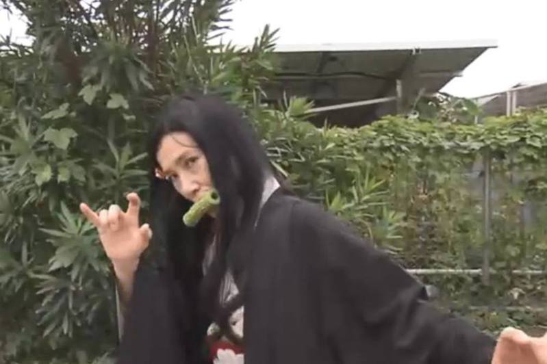 推出「綠色竹輪」食店的老闆娘，為了宣傳產品而扮成禰豆子，更咬着竹輪。（NHK影片截圖）