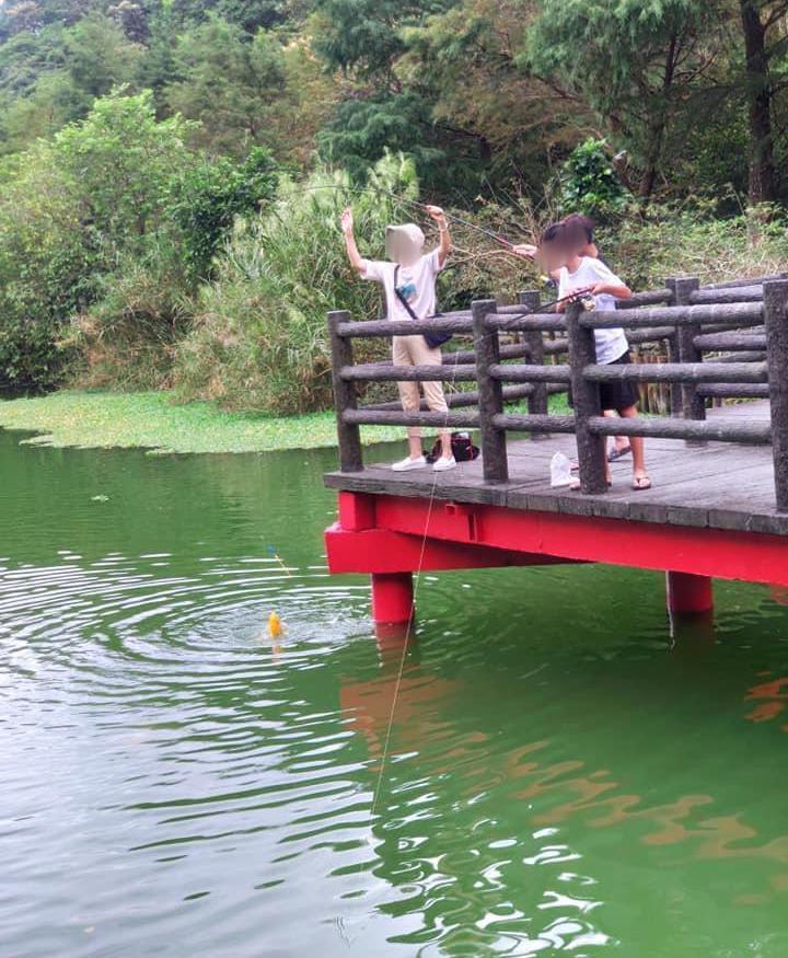 宜蘭望龍埤出現疑似媽媽帶著兩個小孩在湖邊釣鯉魚的離譜事件。 圖擷自爆料公社
