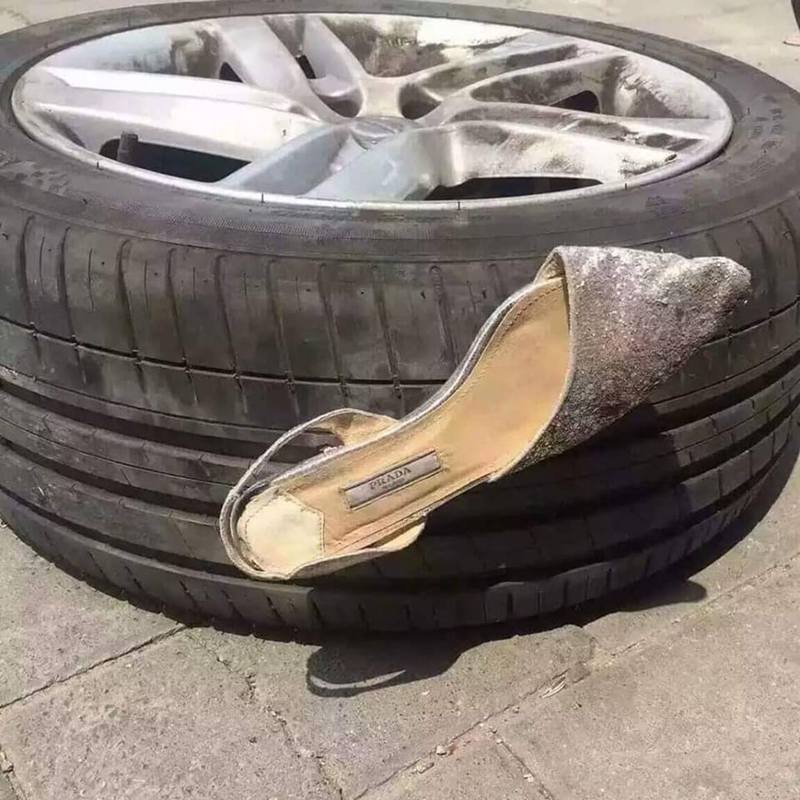 一隻「Prada」品牌的高跟鞋卡在原PO的輪胎上，對此網友戲稱為「穿著Prada的輪胎」。（FB「爆廢公社二館」）