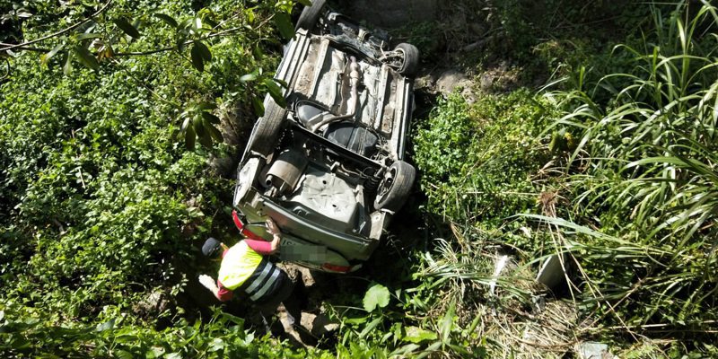 一輛轎車今天中午12點在苗栗縣南庄鄉衝入路旁約5公尺深的山溝，四腳朝天翻覆，車內1家4口一度受困。記者范榮達／翻攝