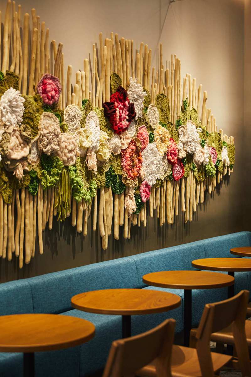 星巴克時代寓所門市藝術牆面，為在地藝術家以真實的咖啡樹枝經過特殊處理後，結合鮮豔的立體藝術編織品呈現出咖啡植栽的變化。圖／星巴克提供