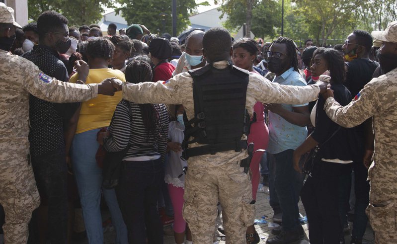 海地警察手拉手组成人链，阻挡民众闯入美国大使馆。（美联社）(photo:UDN)