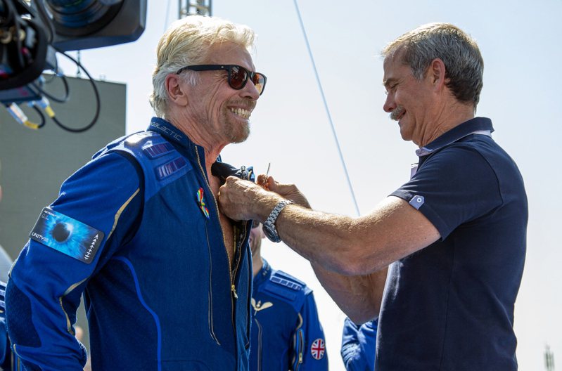 顺利返面后的布兰森(左)10日高兴的接受自加拿大太空人哈费德颁赠的「大空人证章」，加入太空人俱乐部。(美联社)(photo:UDN)