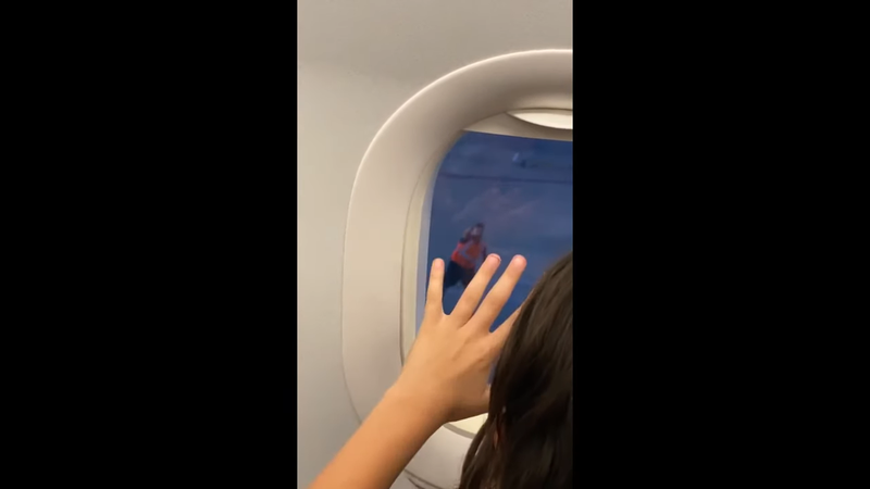 外国一名小孩在飞机上，和外头的工作人员隔窗玩起猜拳，温馨画面感动不少网友。图撷取自(photo:UDN)