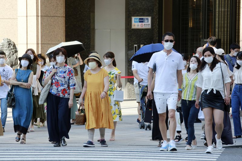 日本東京戴口罩民眾24日經過街頭。美聯社