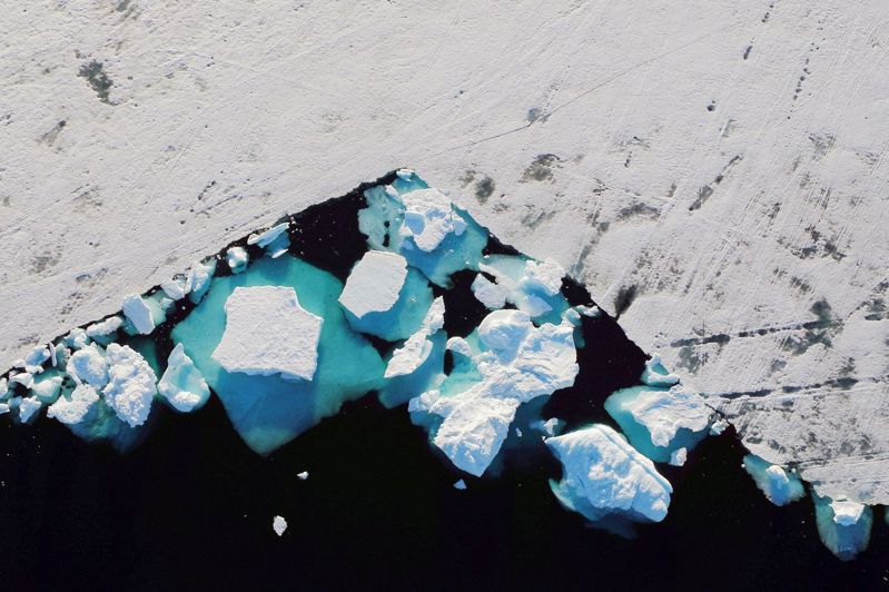 全球暖化正造成北極圈冰層融化速度加快，圖為二○一八年六月漂浮在格陵蘭島塔斯拉克鎮附近峽灣內的一座冰山。（路透）