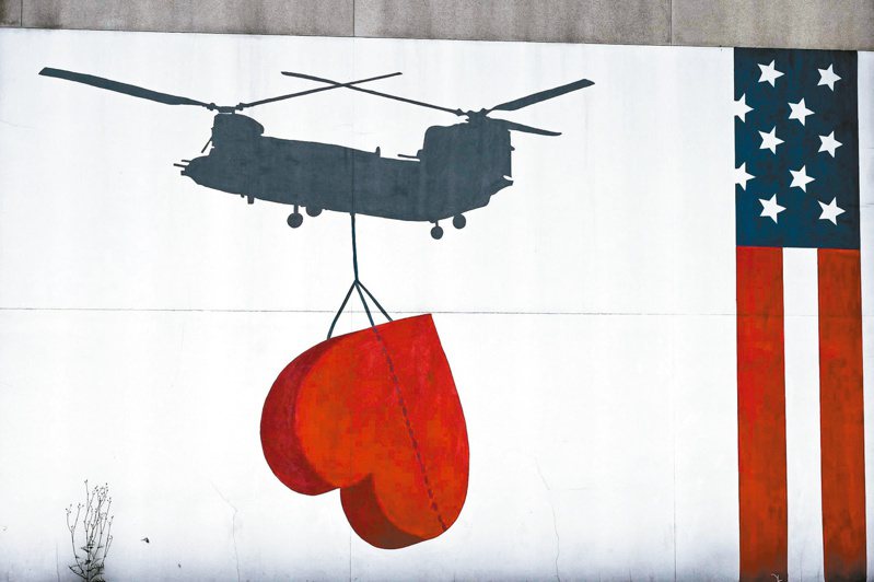 美国驻阿国大使馆外墙绘有军机投递爱心的壁画，如今格外讽刺。（法新社）(photo:UDN)