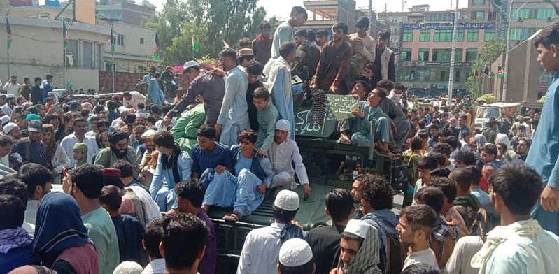 阿富汗东部楠格哈尔省首府贾拉拉巴德街头神学士民兵和当地民众十五日坐在阿富汗国民军的悍马军用汽车上。法新社(photo:UDN)