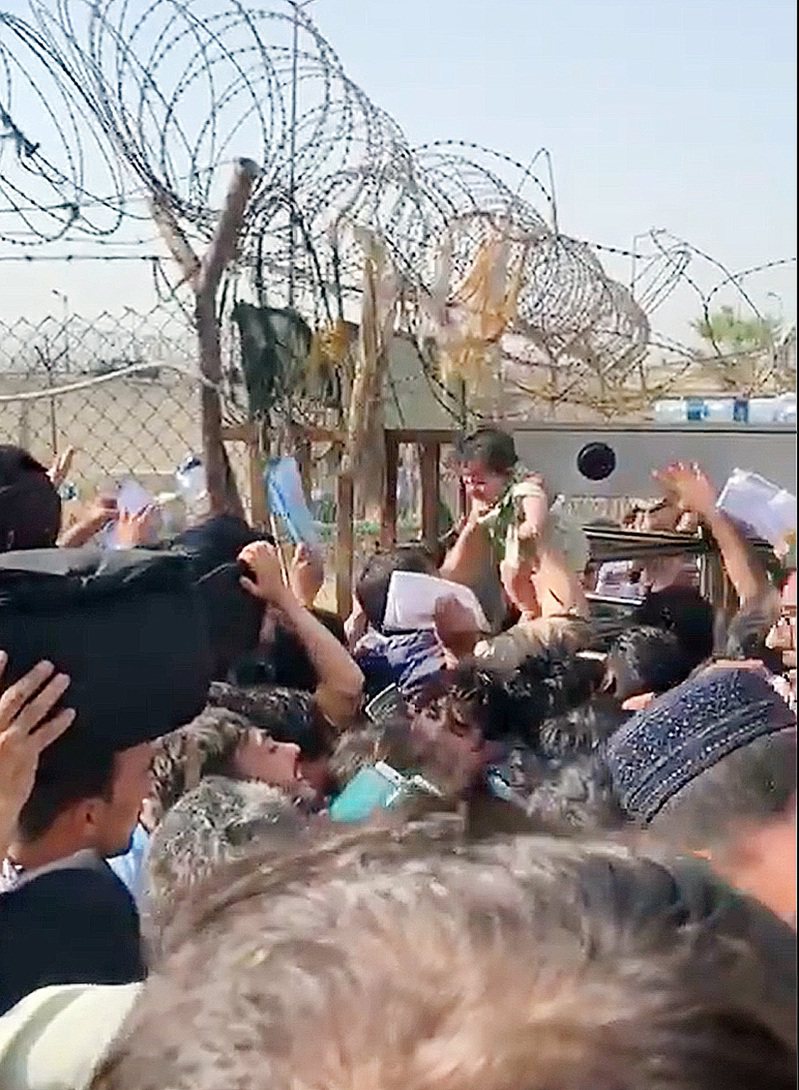 神学士掌控阿富汗后，喀布尔机场涌现逃难人潮，一个小婴孩被以人力方式送进铁丝网封锁区。图╱翻摄自推特(photo:UDN)