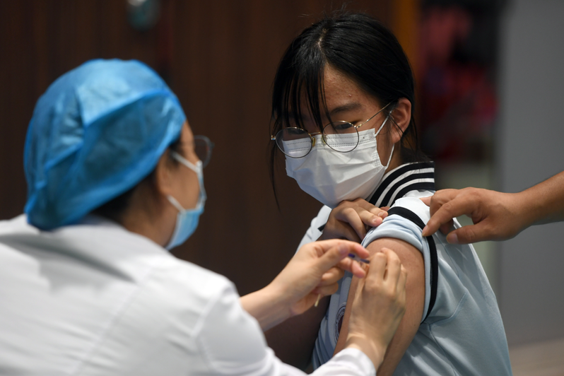 为提高新冠疫苗接种率，大陆各地已陆续开始为12至17岁青少年施打疫苗。图为河南郑州一所中学，19日为学生接种疫苗。新华社(photo:UDN)