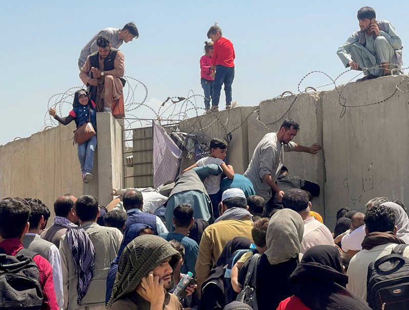 图为日前阿富汗喀布尔机场旁民众争爬围墙，想进入机场，场面混乱。路透(photo:UDN)