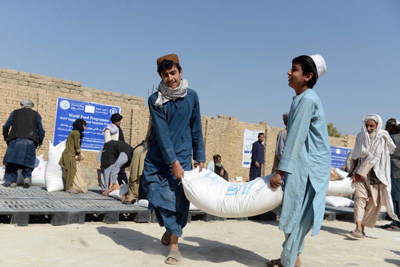 图为阿富汗接头一景，民众领取由世界粮食计划署提供的物资援助。新华社(photo:UDN)