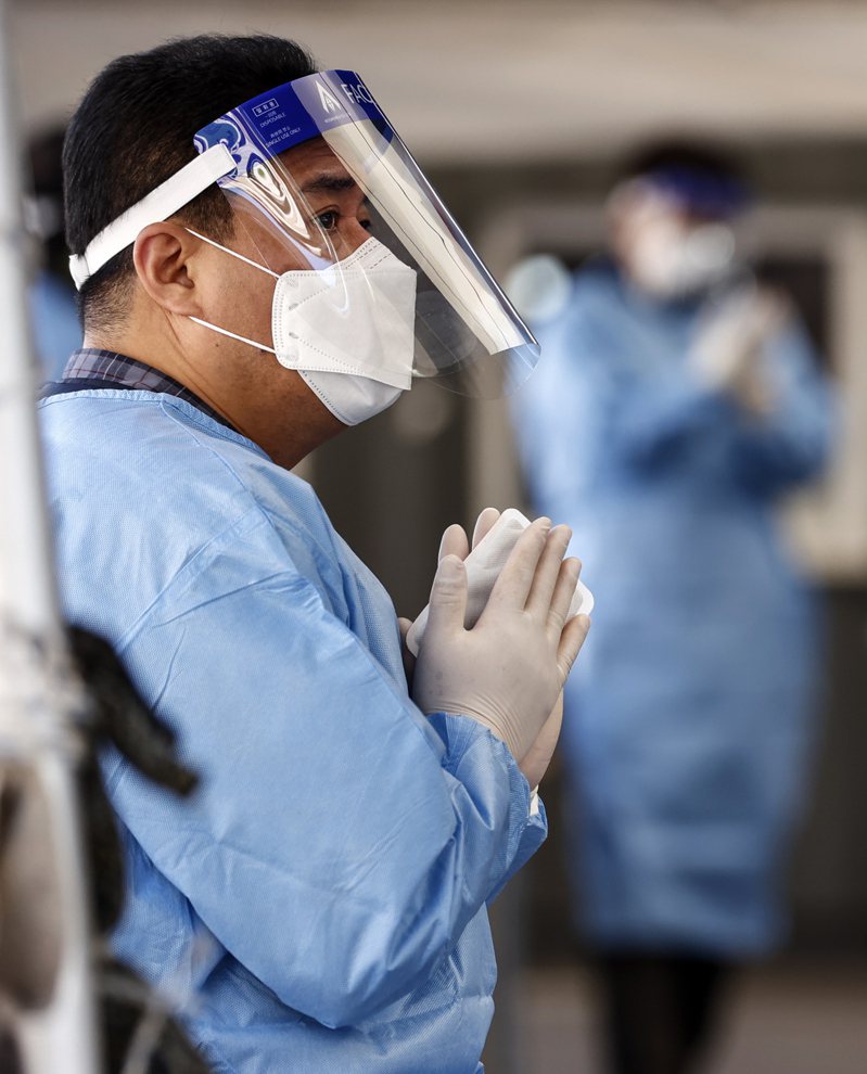 南韩首尔新冠肺炎检测站一名医护人员手握暖暖包抵御寒冷低温。欧新社(photo:UDN)