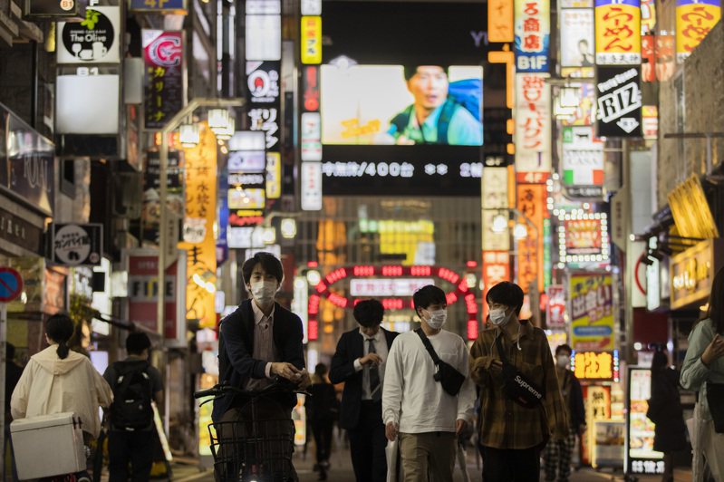 日本东京民众1日晚间行经当地着名娱乐区新宿街头。美联社(photo:UDN)