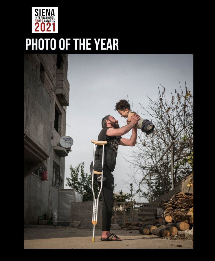 这是今年西恩纳国际摄影大赛「年度最佳照片」，照片中可见一名失去右腿的父亲高举没有四肢的儿子，两人都露出灿烂笑容。图／取自Mehmet Aslan推特(photo:UDN)