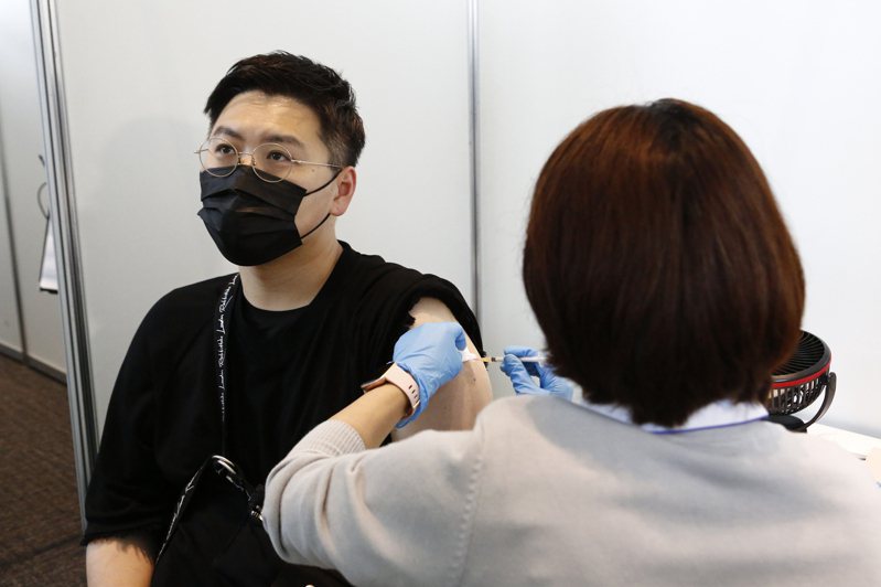 图为日本一名男子在东京都政府大楼接种莫德纳疫苗。美联社(photo:UDN)