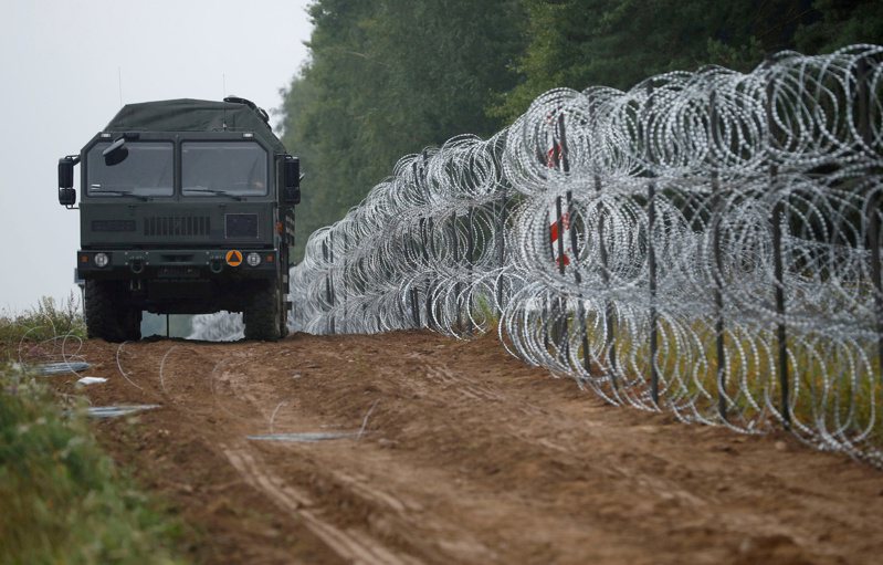 波兰士兵在波兰与白俄罗斯边界筑起刺丝网围篱。路透社(photo:UDN)