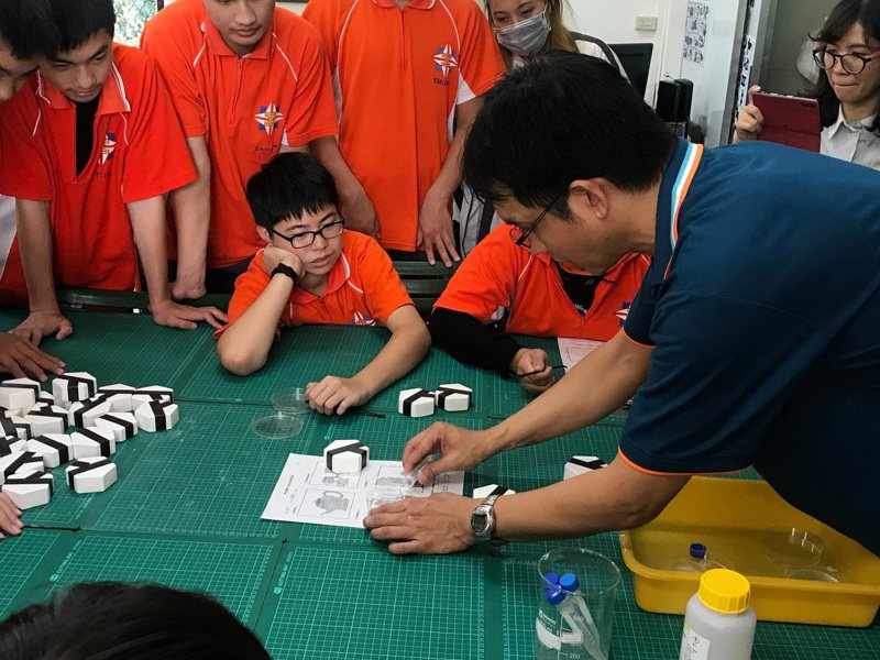 花蓮高工化工科老師閻國中（右一）用桌遊模組，教導學生化學焰色反應的知識。圖／花蓮高工提供