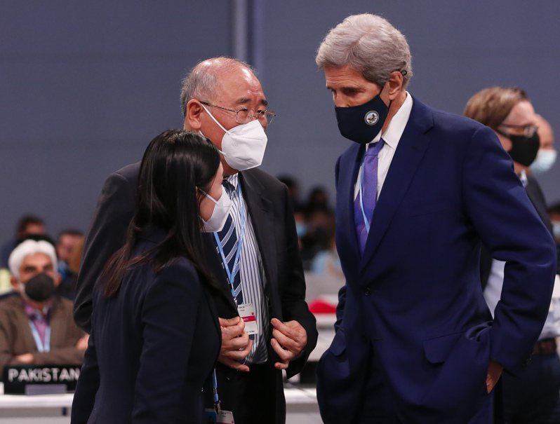 中國大陸氣候變化事務特使解振華（中）十三日在氣候峰會上與美國氣候特使柯瑞（右）交談。（新華社）