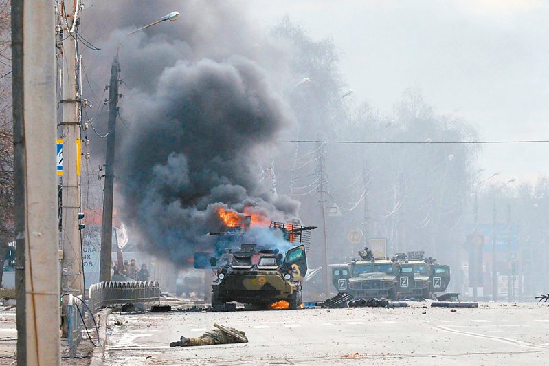 俄烏戰況膠著，圖為兩軍廿六日在烏克蘭第二大城哈爾科夫交戰，一輛俄國裝甲運兵車起火燃燒。法新社