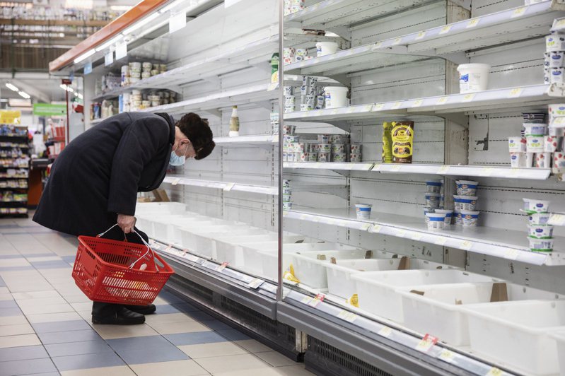 俄国入侵导致乌克兰物资短缺和物流问题，一名老妇人在基辅一间商店的空货架上找寻要採买的物品。（欧新社）(photo:UDN)