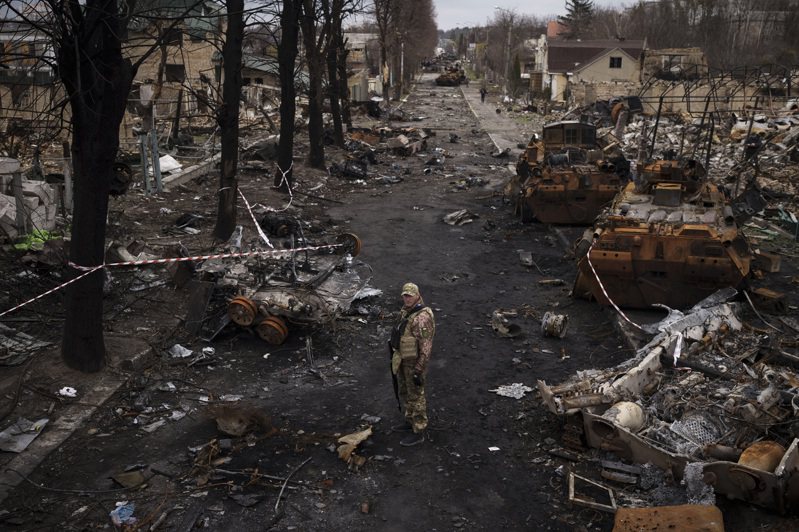 一名乌克兰军人6日站在基辅郊区布查镇的废弃俄军战车旁。（美联社）(photo:UDN)